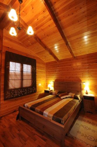 a bedroom with a bed in a wooden room at El Mirador De La Moraña in Hernansancho