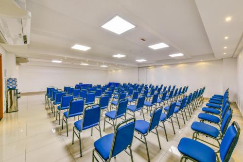 an empty room with blue chairs in a room at Plaza Inn Breeze Aeroporto in Goiânia