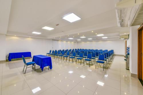 a large room with blue tables and chairs at Plaza Inn Breeze Aeroporto in Goiânia