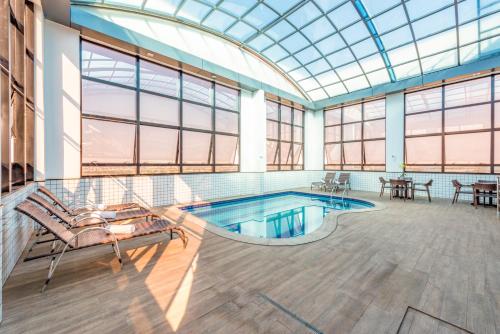 ゴイアニアにあるPlaza Inn Breeze Aeroportoのガラス天井のスイミングプール付きの広い客室です。