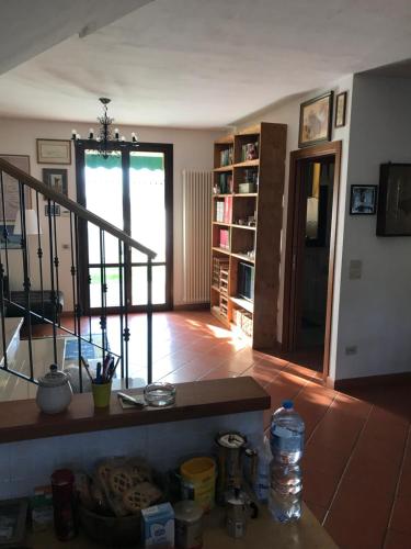 a living room with a staircase and a table with a water bottle at Casa Riccardo in Tavullia