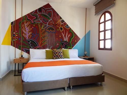 um quarto com uma cama grande e uma pintura na parede em ETHNIC Thematic Hotel em Cartagena de Indias