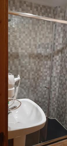a bathroom with a sink and a shower at Pensión CASA LEÓN in Santoña
