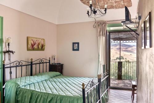 a bedroom with a bed with a green comforter at Le Querce di Cota in Troina