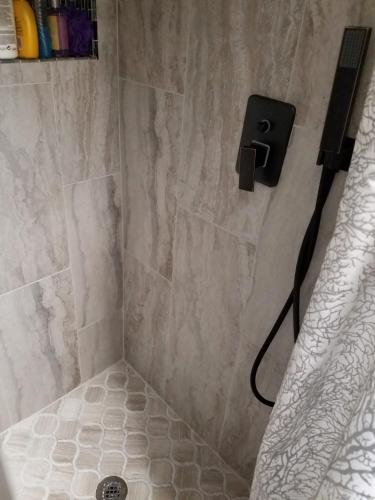 a bathroom with a shower with a phone on the wall at Hampton House in Clinton