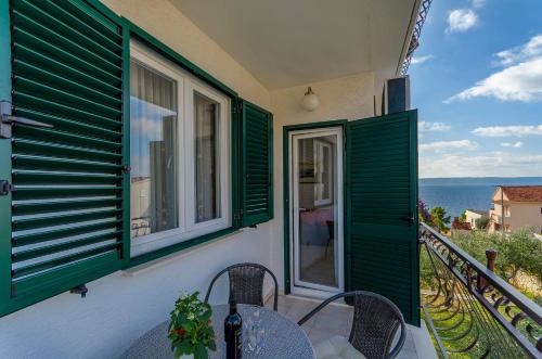 - un balcon avec volets verts, table et chaises dans l'établissement Apartments Mate, à Trogir
