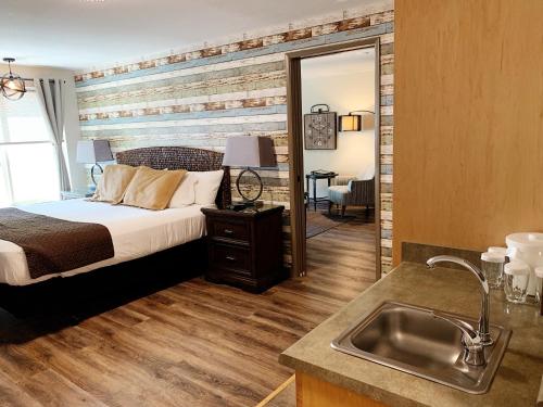 a bedroom with a bed and a sink and a mirror at Stratford Inn in Ashland