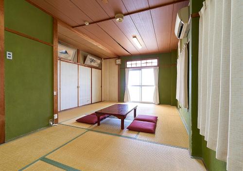 an empty room with a table and a window at Minshuku Atsuhama in Sumoto