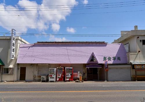 a building with a purple roof on the side of a street at Minshuku Atsuhama in Sumoto