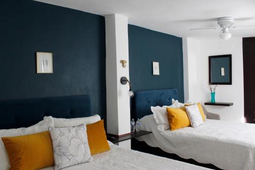 Un dormitorio con 2 camas y una pared de acento azul en Suites ciento 37, en León