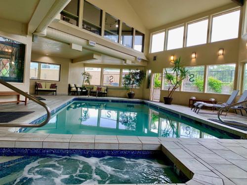 a swimming pool in a large house with windows at Stratford Inn in Ashland