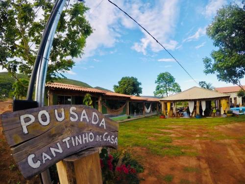 a sign in front of a resort with a building at Pousada Cantinho de Casa in Nobres