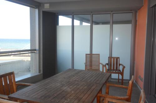 a dining room with a table and chairs and the ocean at Appartamenti Lungomare Savona in Savona