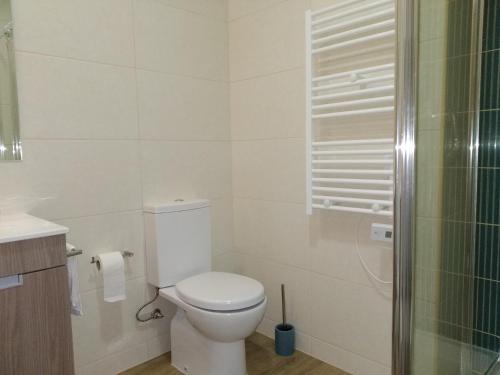 a white bathroom with a toilet and a shower at Casa Do Boteco in Santa Marta de Penaguião