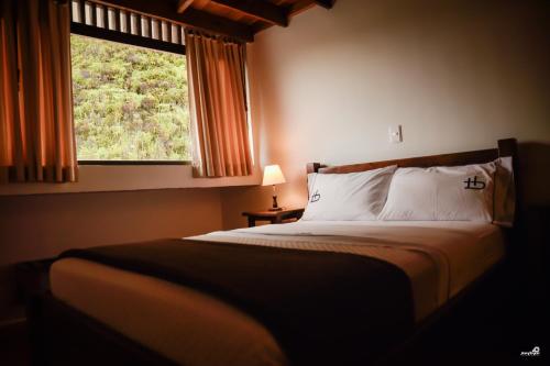 a bedroom with a large bed with a window at Ecohotel Bordones in Isnos