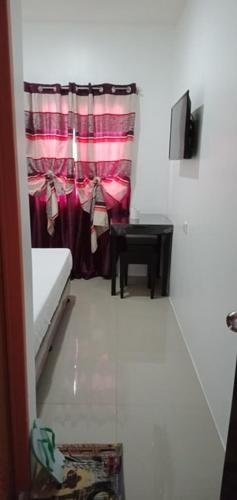 a small room with a curtain and a table at Lei Kendee in Digos