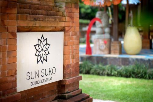 a sign on the side of a brick wall at Sun Suko Boutique Resort in Pemuteran