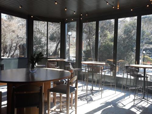 a room with tables and chairs and windows at House of Ullr in Thredbo