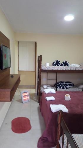 a room with two bunk beds and a tv at Suites Bella vista in Campos do Jordão
