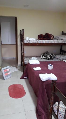 a bedroom with two bunk beds and a red rug at Suites Bella vista in Campos do Jordão