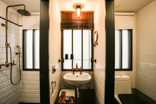 a bathroom with a sink and a toilet and a window at Hotel PaPa Whale in Taipei