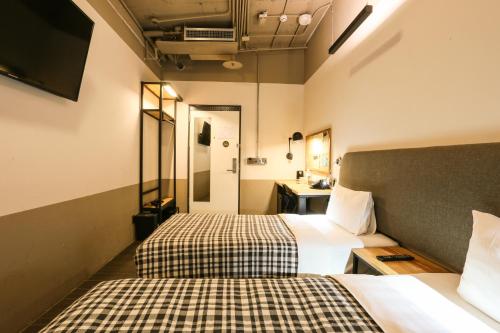 a hotel room with two beds and a bathroom at Hotel PaPa Whale in Taipei