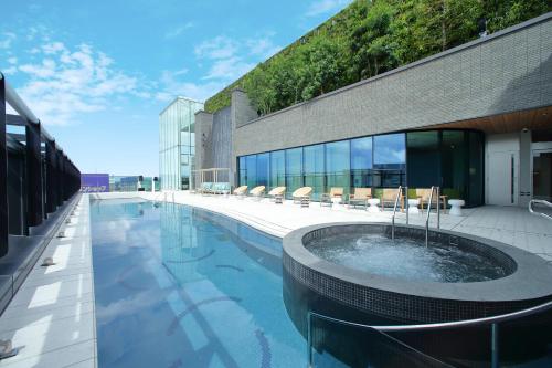 a swimming pool with a hot tub in the middle of a building at Miyako Hotel Hakata in Fukuoka