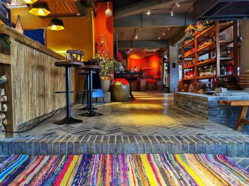 a restaurant with a colorful rug on the floor at The Twelve Manor•Terraces Lodge in Yuanyang