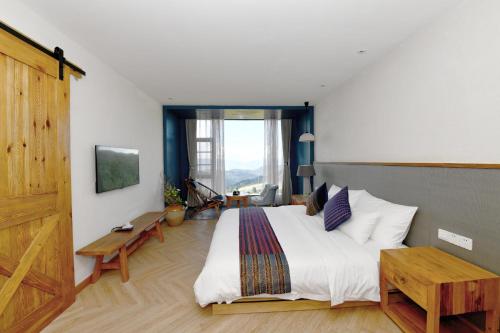 a bedroom with a large bed and a large window at The Twelve Manor•Terraces Lodge in Yuanyang