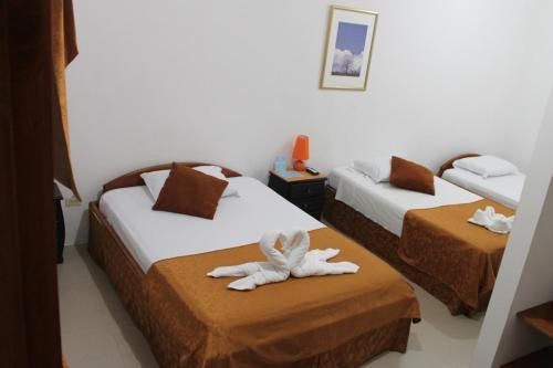 a hotel room with two beds with towels at New Galapagos Hostelling in Puerto Ayora