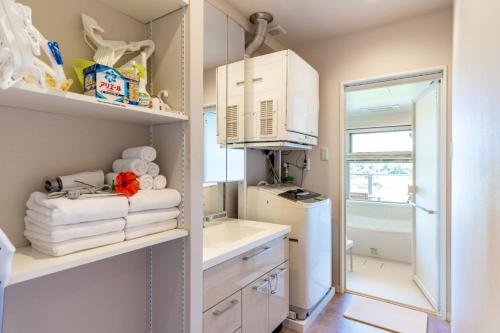 a small kitchen with white cabinets and a refrigerator at Ocean Resort Maeda / Vacation STAY 3223 in Onna