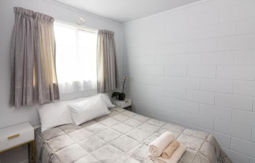 a bedroom with a bed with towels on it at Kaitaia Motor Lodge in Kaitaia