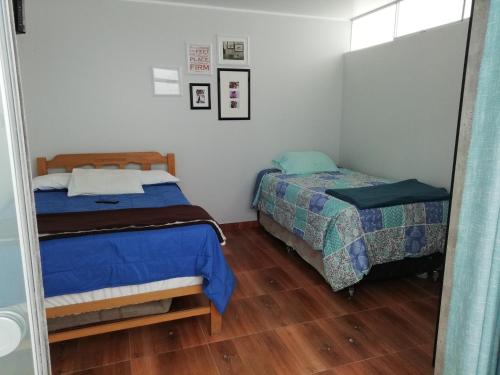 a bedroom with two beds and a mirror at Casa Blue Hill Beach in Cerro Azul