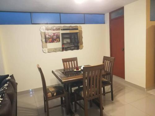 ein Esszimmer mit einem Tisch, Stühlen und einer Mikrowelle in der Unterkunft Apartamento amueblado, cómodo e independiente en Huancayo in Huancayo