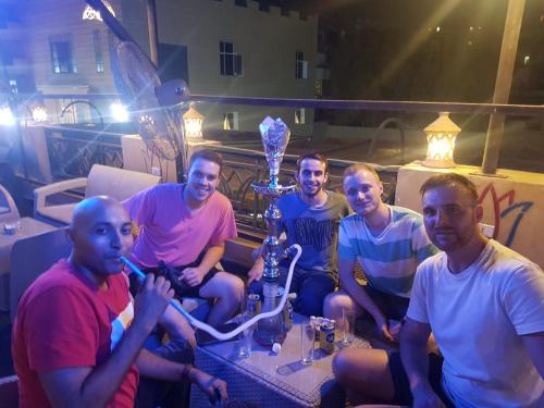 a group of men sitting around a table with a trophy at H100 Pyramids View in Giza