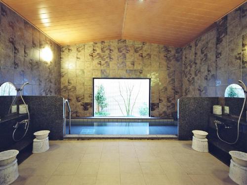a bathroom with a swimming pool and a window at Hotel Route-inn Natori in Natori
