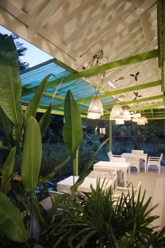 a restaurant with white tables and chairs and plants at Baan Bua Cottage SHA EXTRA PLUS B5510 in Ko Kood