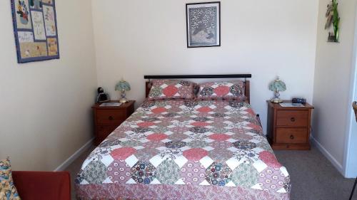 a bedroom with a bed with a quilt on it at Rivendell in Geraldine