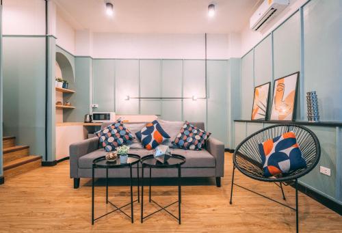 a living room with a couch and a table and chairs at Saffron Hill Bangkok in Bangkok