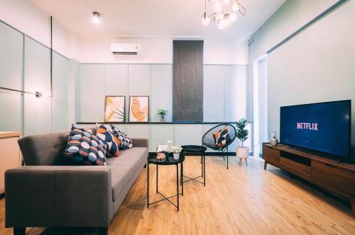 a living room with a couch and a tv at Saffron Hill Bangkok in Bangkok