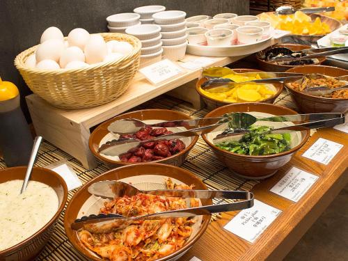 a table with many different dishes of food on it at Hearton Hotel Shinsaibashi in Osaka