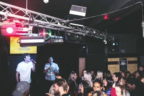 a man standing on a stage in a crowd of people at Newcastle Hotel in Newcastle