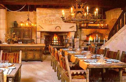 a dining room with a long table and a fireplace at Auberge de l'Abbatiale in Auberive