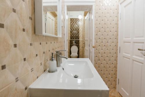 a bathroom with a white sink and a toilet at Апартамент ELSOR in Burgas City