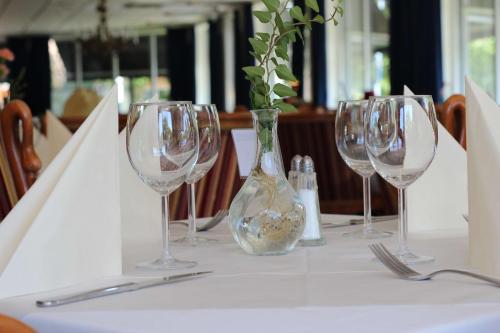 a table with four wine glasses and a vase on it at Best Western Hotel Varnamo in Värnamo