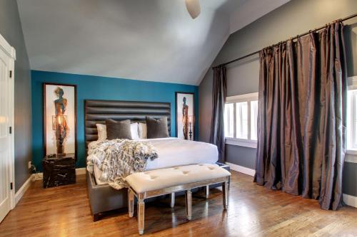 a bedroom with blue walls and a bed with a bench at Hotel Finial BW Premier Collection Oxford - Anniston in Anniston