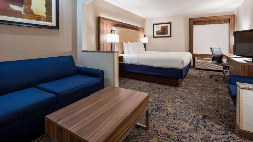a hotel room with a bed and a couch at Best Western Plus Kansas City Airport - KCI East in Kansas City