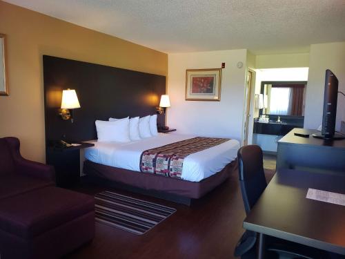 オキーチョビーにあるベスト ウエスタン オキチョビーのベッドとデスクが備わるホテルルームです。
