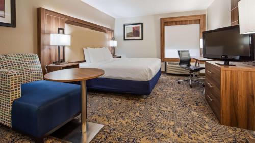 a hotel room with a bed and a flat screen tv at Best Western Plus Kansas City Airport - KCI East in Kansas City