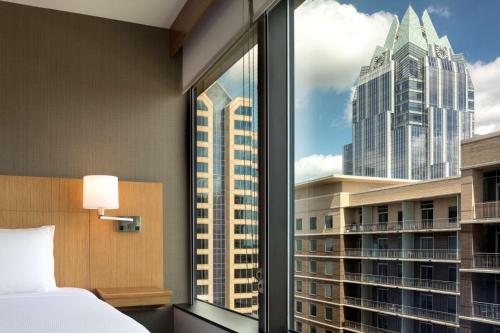 a bedroom with a window with a view of a city at Hyatt Place Austin Downtown in Austin